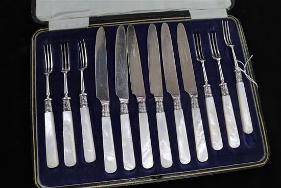 A cased set of six pairs of mother of pearl handled dessert eaters with silver collars.